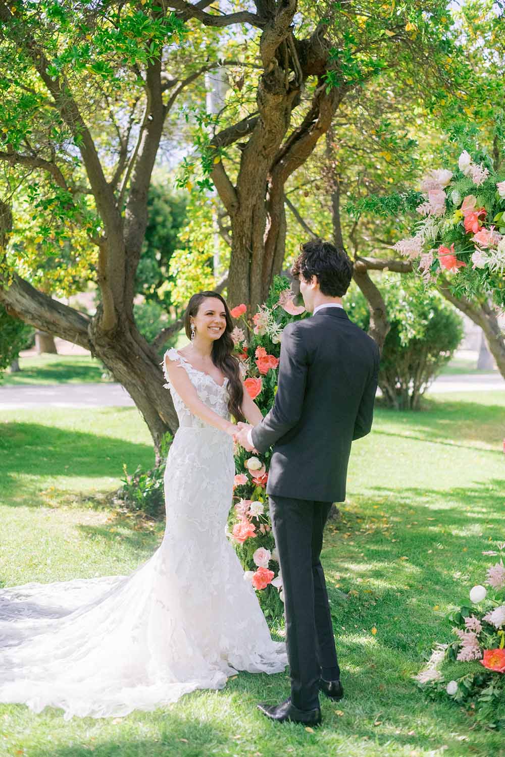 une mariée dans une robe monique l'huillier devant une arche avec son mari